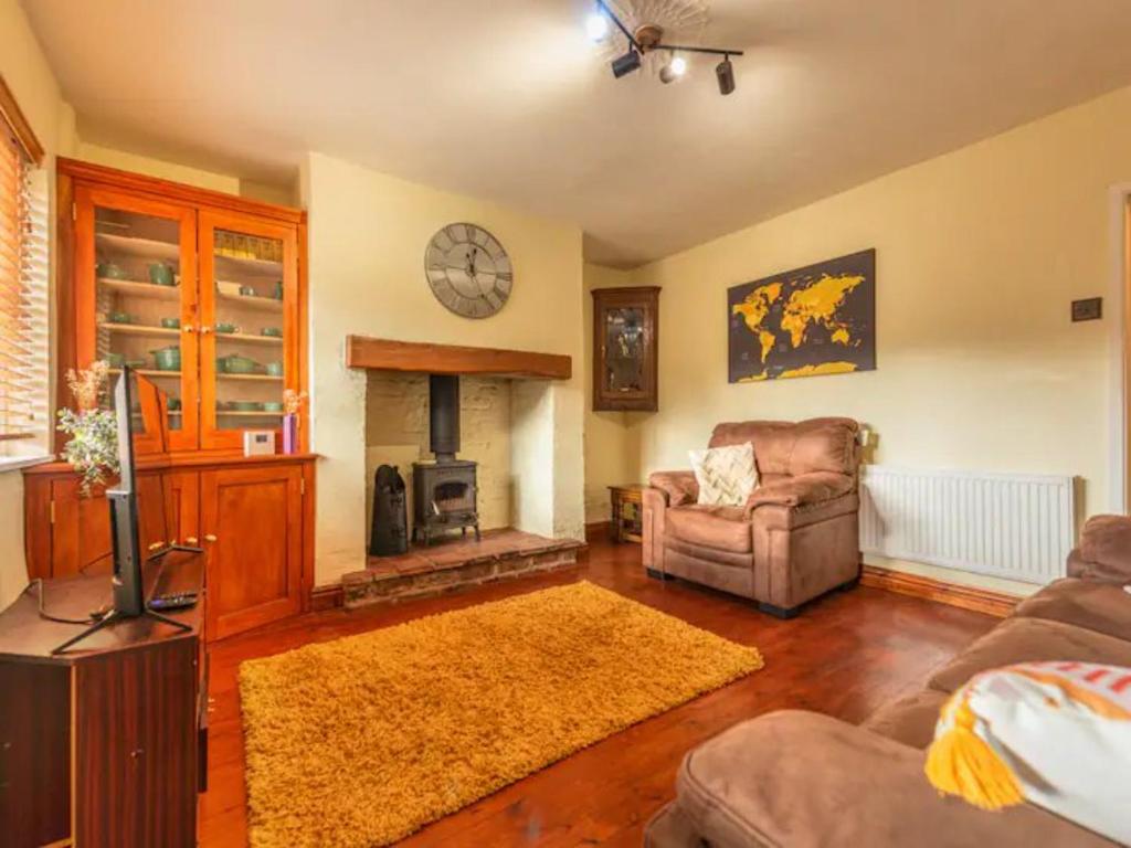 a living room with a couch and a fireplace at Pass the Keys Cosy Miners Cottage in Telford