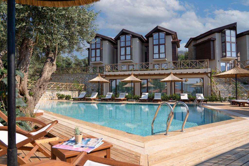 a hotel with a swimming pool in front of a building at Boho Garden Selimiye in Selimiye