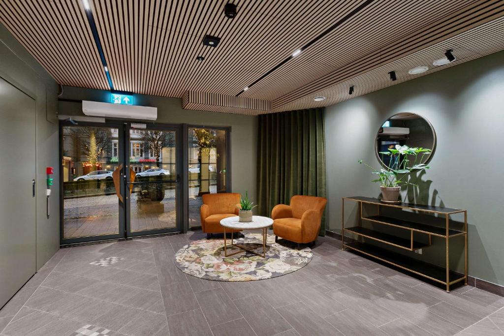 a lobby with chairs and a table and a mirror at Ole Bull, Best Western Signature Collection in Bergen