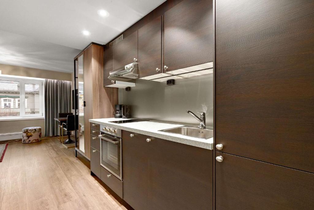 a kitchen with wooden cabinets and a sink at Ole Bull, Best Western Signature Collection in Bergen