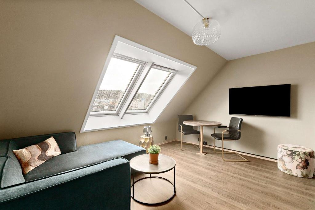 a living room with a couch and a tv at Ole Bull, Best Western Signature Collection in Bergen