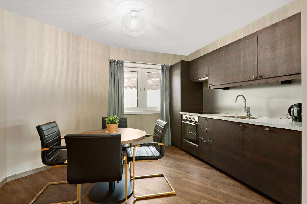 a kitchen with a table and chairs in a room at Ole Bull, Best Western Signature Collection in Bergen