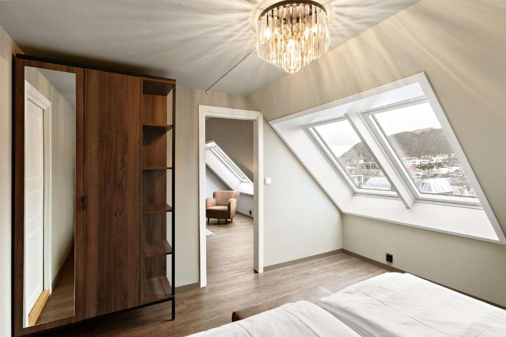 a bedroom with a bed and a chandelier at Ole Bull, Best Western Signature Collection in Bergen