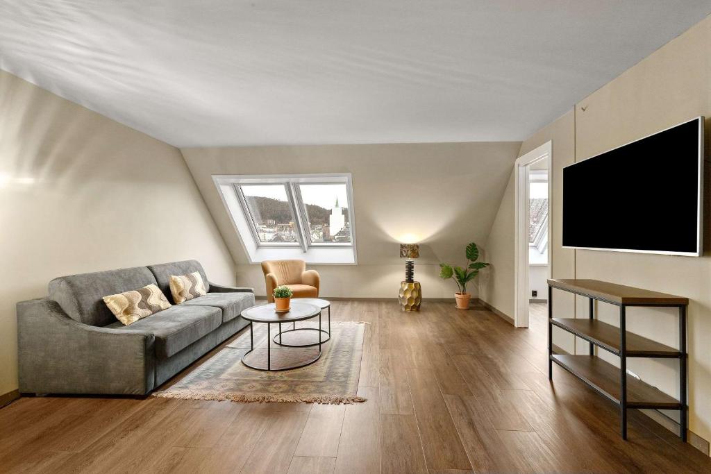 a living room with a couch and a flat screen tv at Ole Bull, Best Western Signature Collection in Bergen