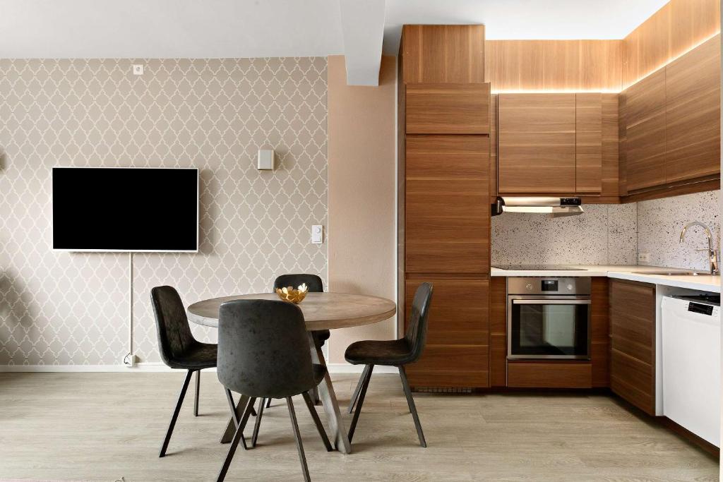 a kitchen with a table and chairs and a tv at Ole Bull, Best Western Signature Collection in Bergen