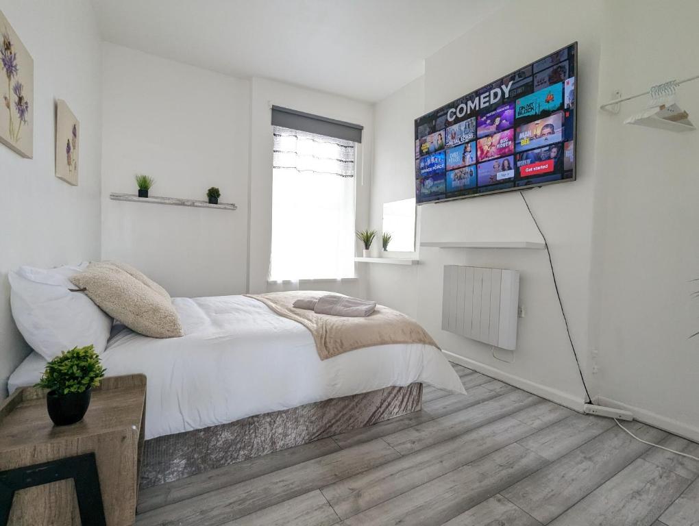 a bedroom with a bed and a television on the wall at Inner-City Apartments - Basic Amenites in Cardiff