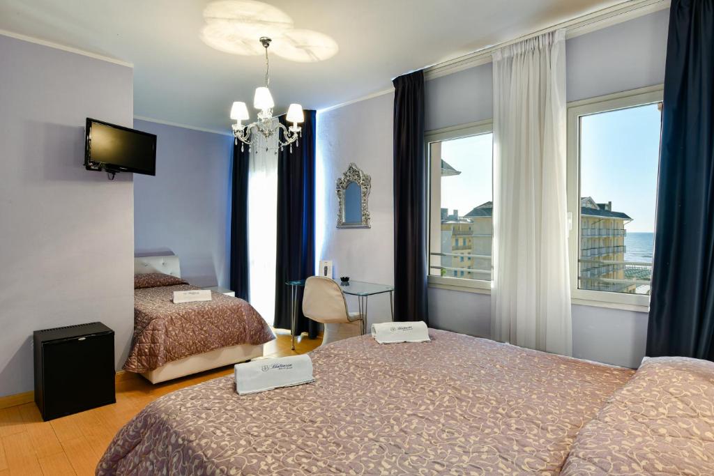 una camera d'albergo con due letti e una finestra di HOTEL BLUMARIN a Lido di Jesolo