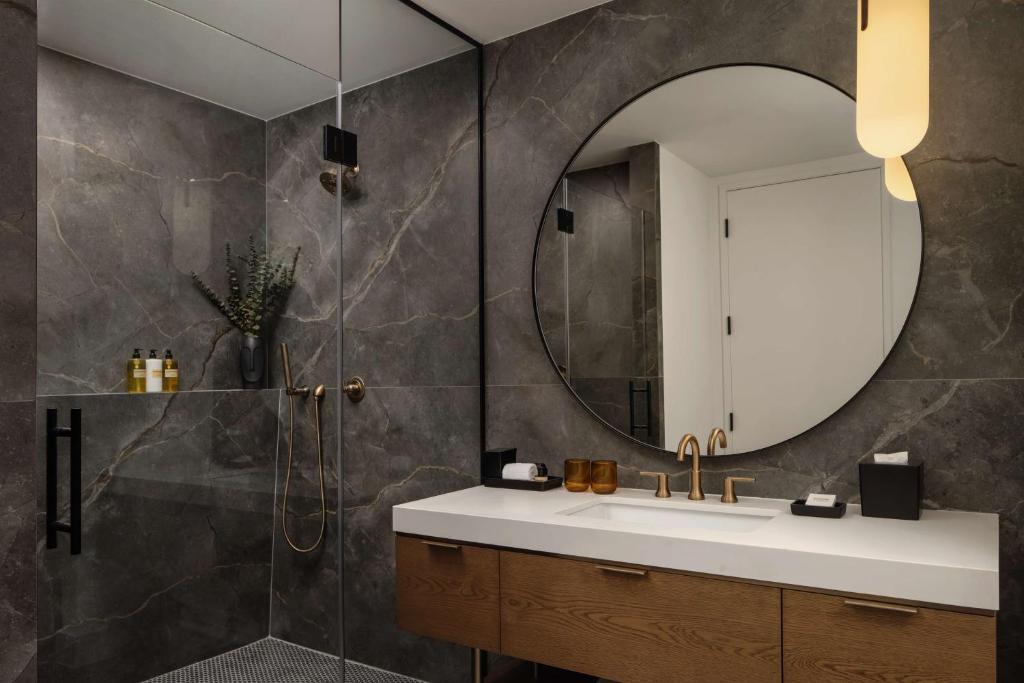 a bathroom with a sink and a mirror at Thompson Houston, by Hyatt in Houston