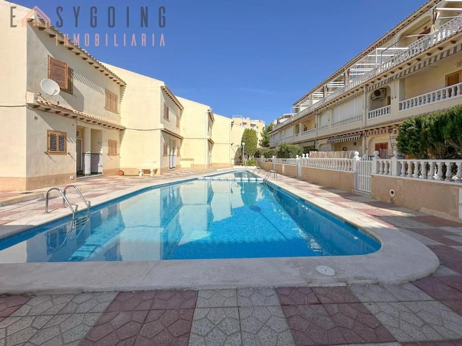 a swimming pool in a courtyard of a building at Casa Blanca 1 in Santa Pola