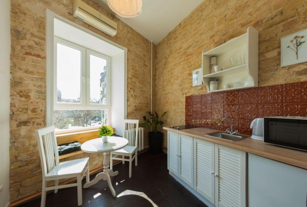 a kitchen with a sink and a table with chairs at Kyiv Prince Apartment in Kyiv