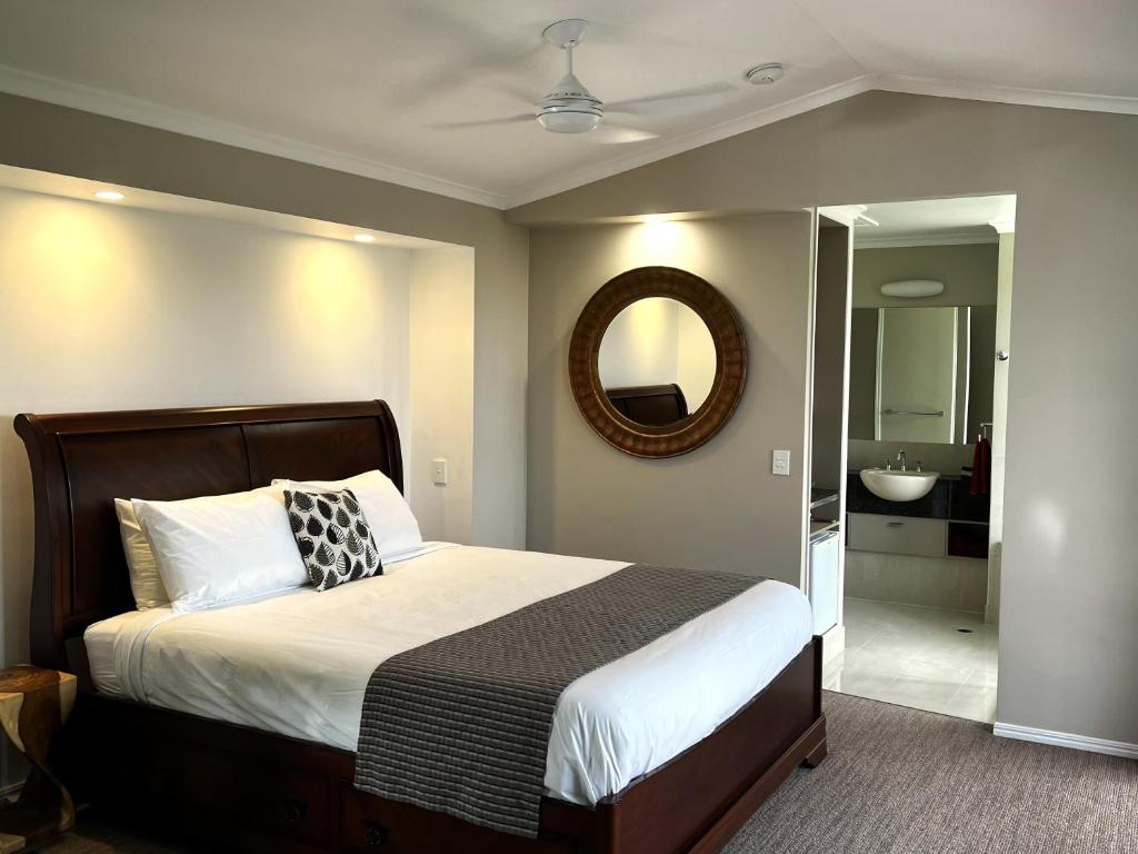 a bedroom with a bed and a mirror and a bathroom at Top Of The Hill in Maleny