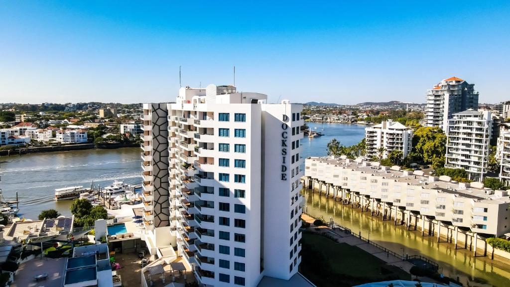 eine Luftansicht eines weißen Gebäudes neben einem Fluss in der Unterkunft Dockside Brisbane in Brisbane
