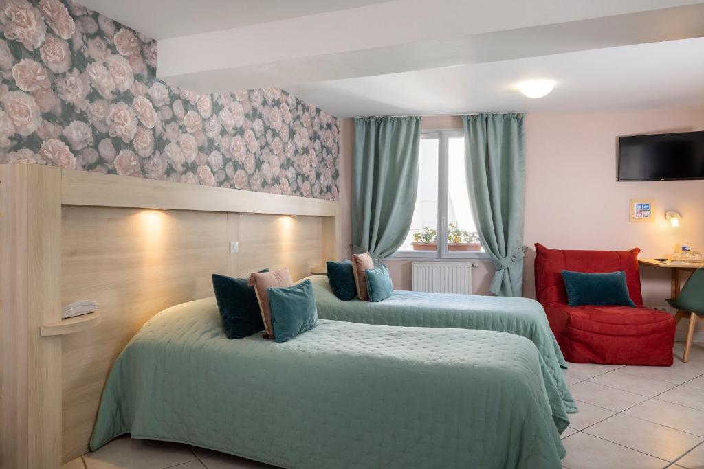 a hotel room with two beds and a red chair at Hôtel de Lion sur Mer in Lion-sur-Mer