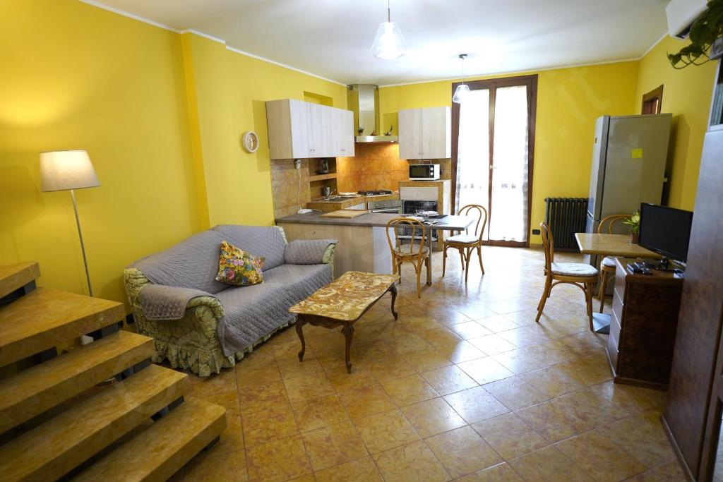 a living room with a couch and a kitchen at Case Ospitali - Corte Nuova appartamento in corte storica con due camere e due bagni in Caponago