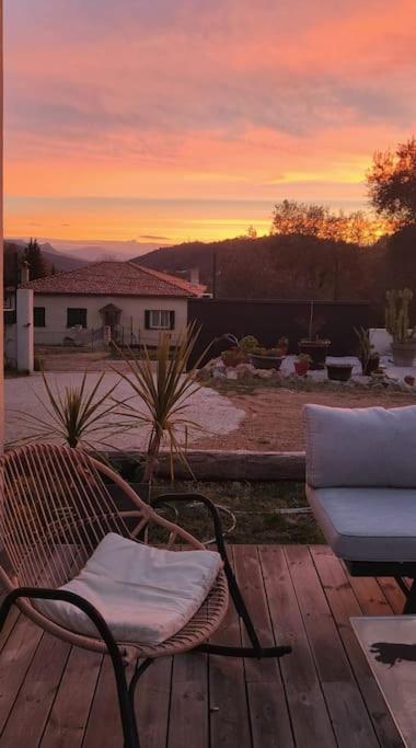 a chair and a couch on a deck with a sunset at New ! Pura Vida - Villa familiale récente à Châteauneuf de Grasse in Châteauneuf