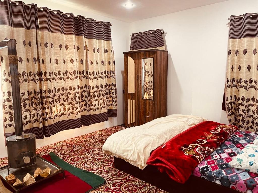 a bedroom with a bed in a room with curtains at Sunset View Gulmarg in Gulmarg
