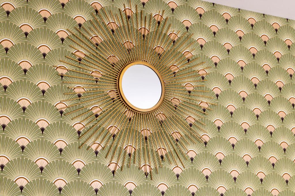 an image of a ceiling with a mirror at Hôtel de Lion sur Mer in Lion-sur-Mer