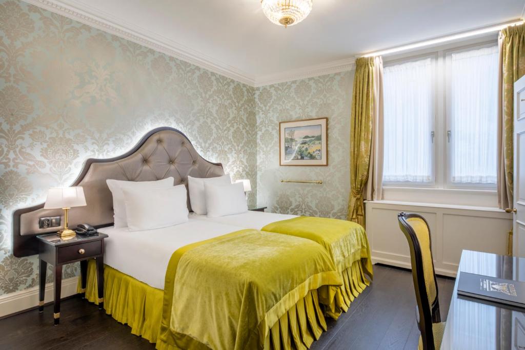 Cette chambre d'hôtel comprend un lit avec une couverture jaune. dans l'établissement Stanhope Hotel by Thon Hotels, à Bruxelles