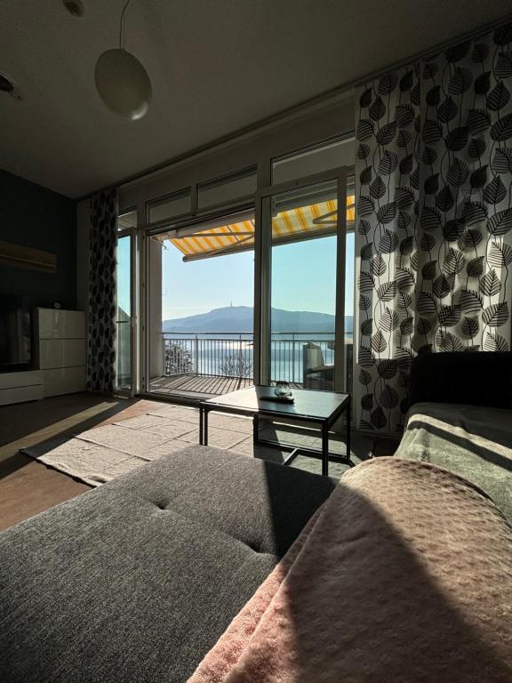 a bedroom with a bed and a view of a balcony at Appartement mit Seeblick & Seezugang in Sekull