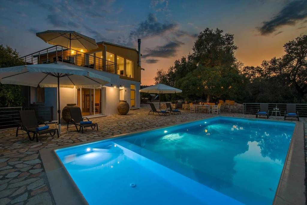 a swimming pool in front of a house at Elisabetta Villa by PaxosRetreats in Gaios
