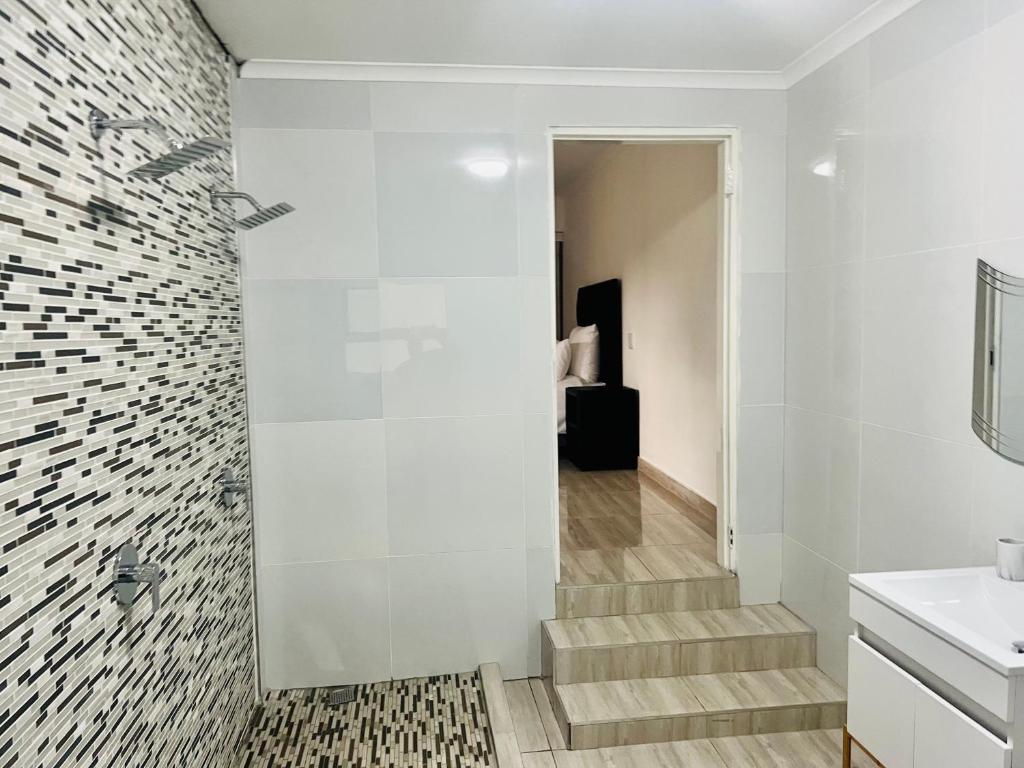 Del Judor的住宿－Zindiza Guesthouse 2，浴室拥有白色的墙壁、楼梯和水槽