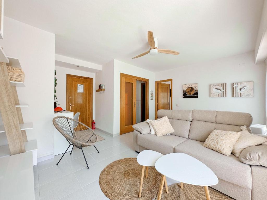 a white living room with a couch and a table at 400m playa con WiFi AC y piscina in Puerto de Gandía