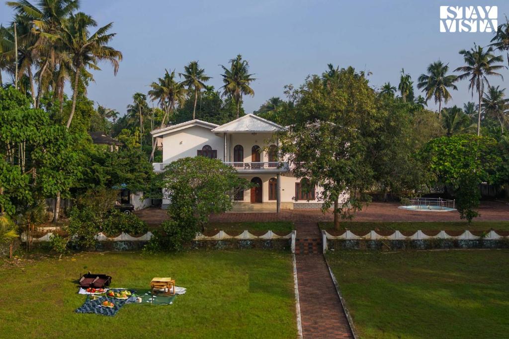 a house with a lawn in front of it at StayVista at Periyar Palace- Pet Friendly, River View Villa with Garden in Cochin