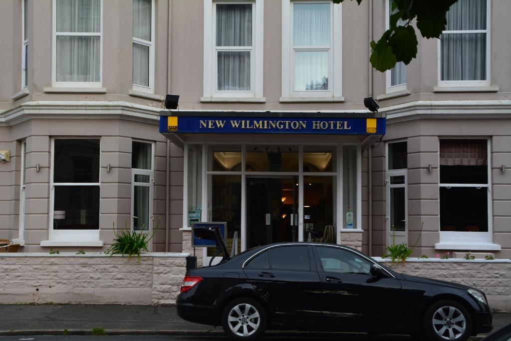 um carro preto estacionado em frente a um novo hospital de validação em New Wilmington Hotel em Eastbourne