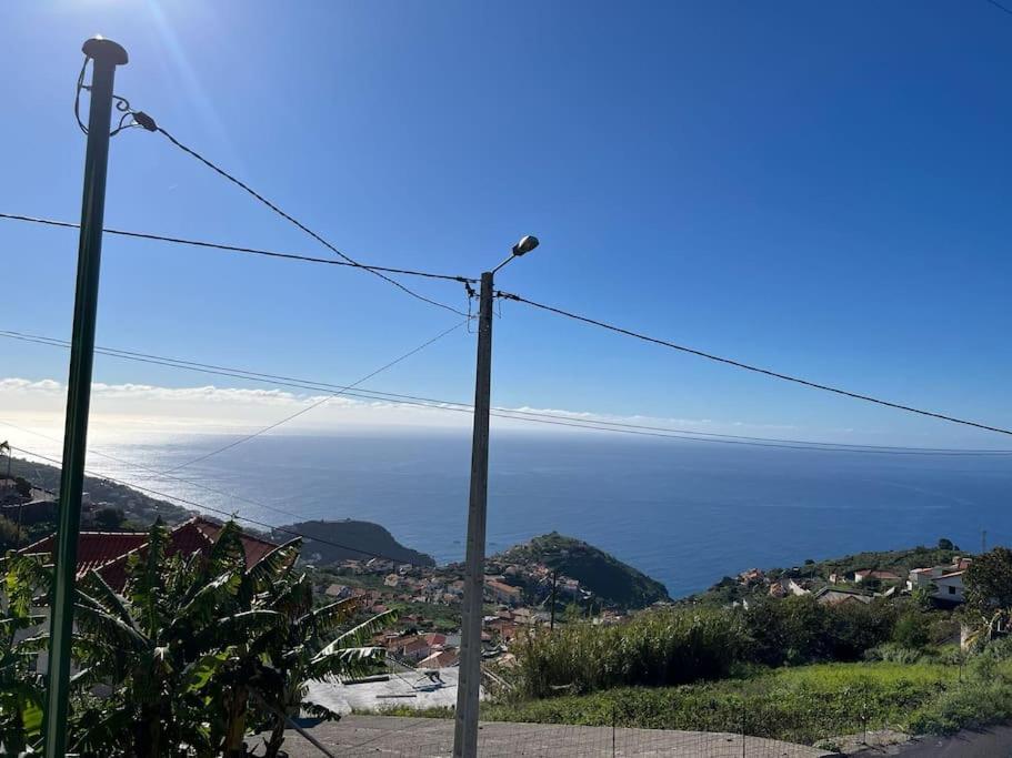 a telephone pole with the ocean in the background at Fernanda's House in Ribeira Brava