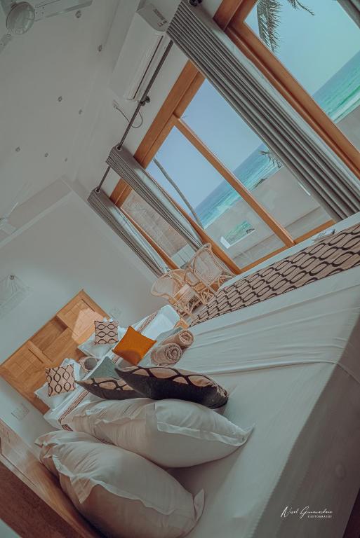 a room with a bed with a skylight and a window at MANTA RAY MANOR HAVEN -Nestled on Sri Lanka's Southern Coast, offers Luxurious rooms with Ocean, Garden, & Pool Views, a Private Beach, Ocean-View Pool with a Jacuzzi, & Event Hosting & more, your Perfect Escape for Relaxation & Unforgettable Moments in Ahangama