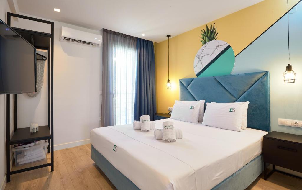 um quarto com uma cama grande e uma cabeceira azul em Urban Elephant Suites em Tessalónica