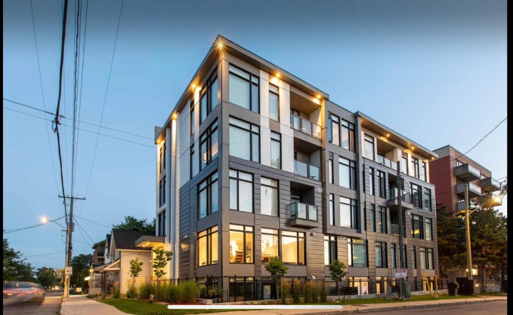 a tall building with lights on it on a street at Westview Luxury Suites in Ottawa