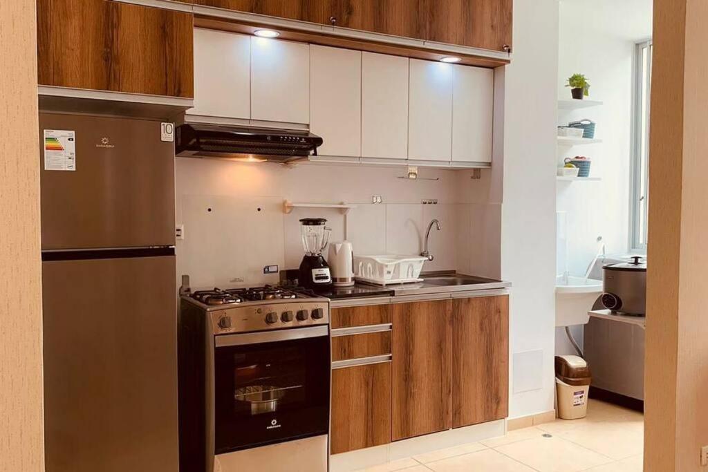 a kitchen with white cabinets and a stove top oven at Departamento Piura in Piura