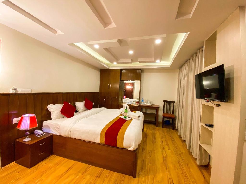 a bedroom with a large bed and a television at Hotel Abi International in Kathmandu