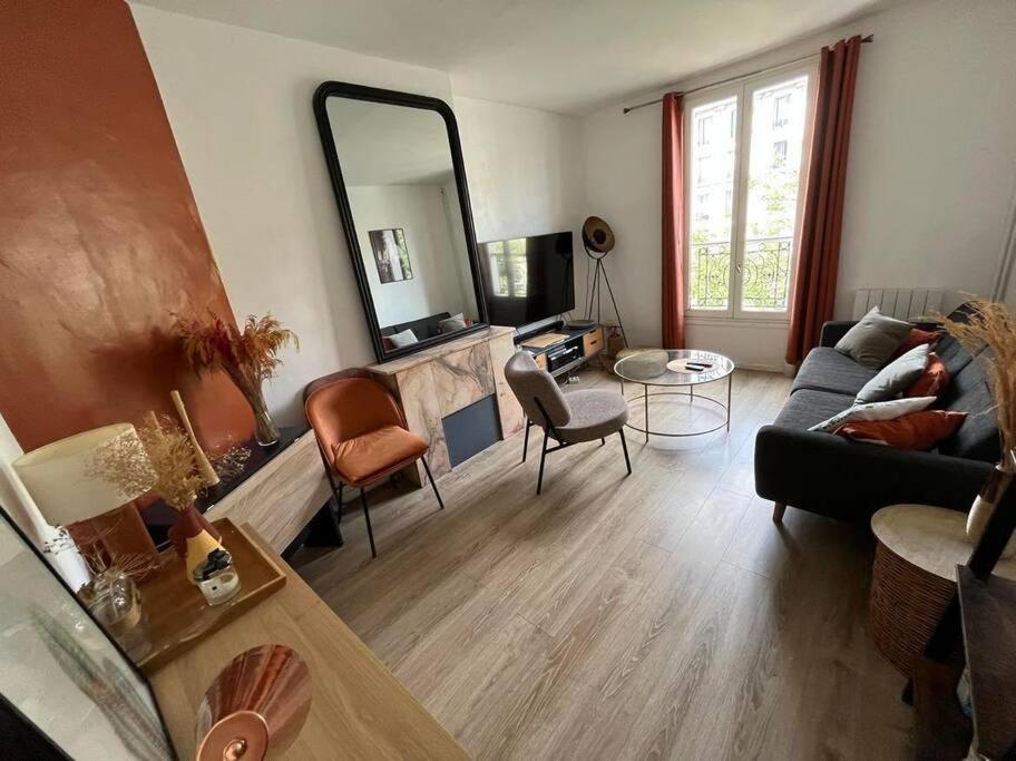 ein Wohnzimmer mit einem Sofa und einem Spiegel in der Unterkunft Nice flat Paris 16 near to Eiffel Tower in Paris