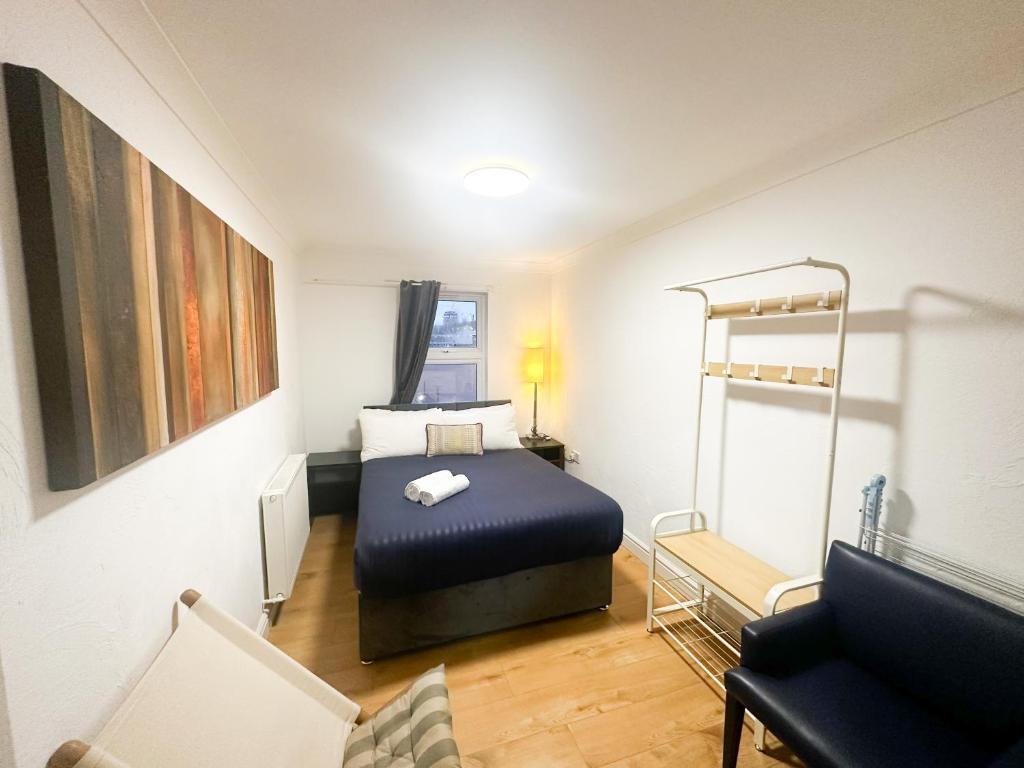 a small room with a bed and a chair at Flat 4, Stay in Aldgate in London
