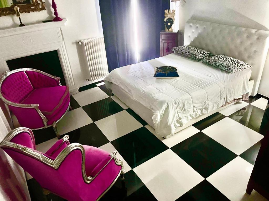 a room with a bed and a chair with a chair at B&B dell'orologio in Acquaviva delle Fonti