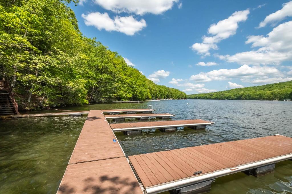 a dock on a lake with benches in the water at Lured by the Lake in Swanton