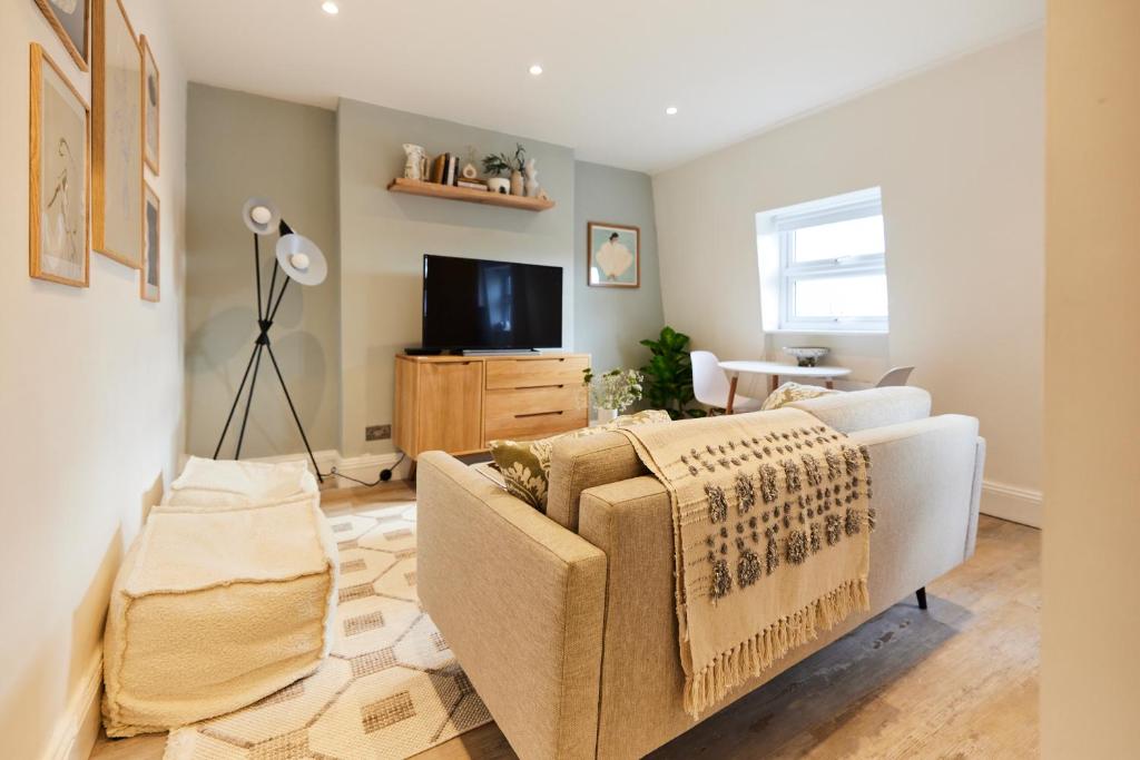 a living room with a couch and a tv at The North Notting Hill Crib - Bright 1BDR Flat in London