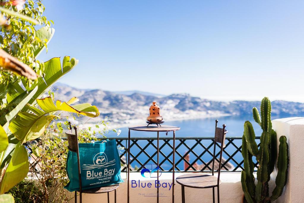 Una mesa en un balcón con vista al mar. en Al Alba Townhouse with Community Pool and Padel, en La Herradura