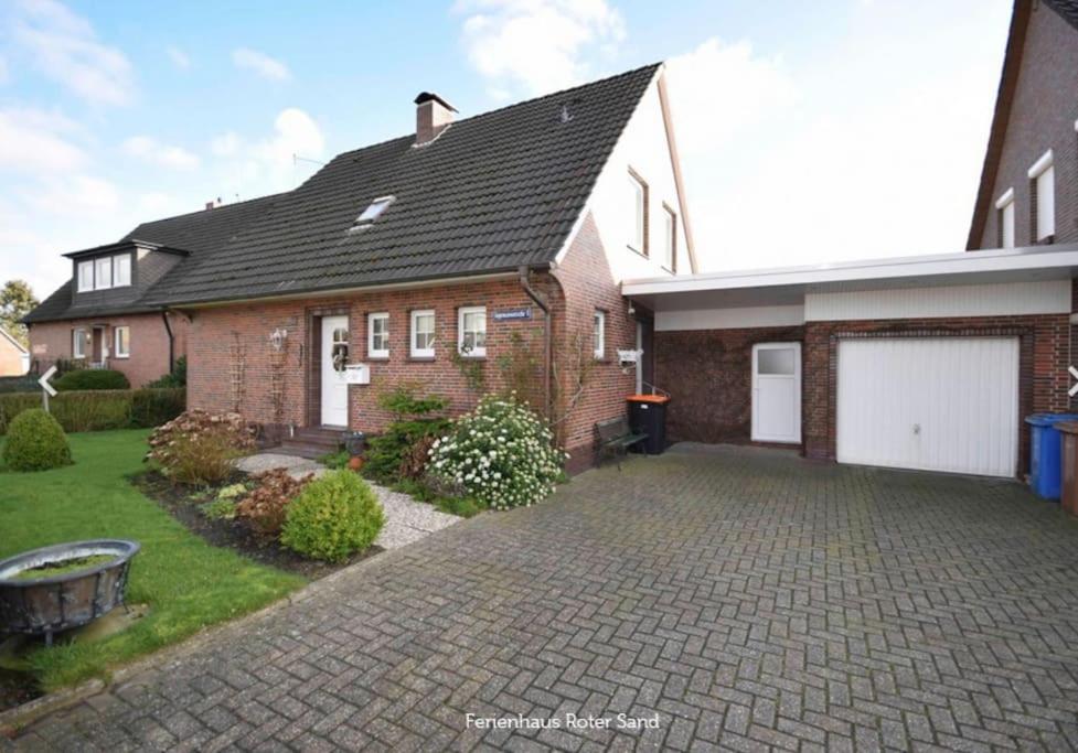 a brick house with a driveway in front of it at Haus Roter Sand in Hooksiel in Wangerland
