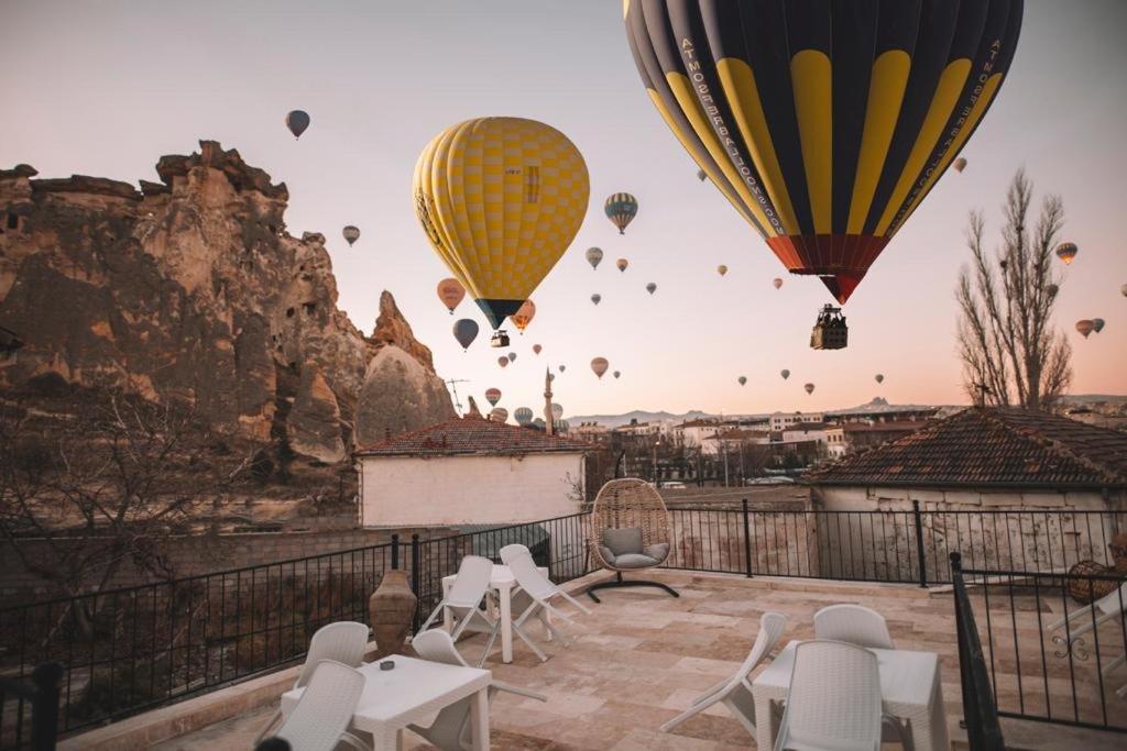 un grupo de globos de aire caliente volando en el cielo en DAPHNE CAVE HOTEL, en Avanos