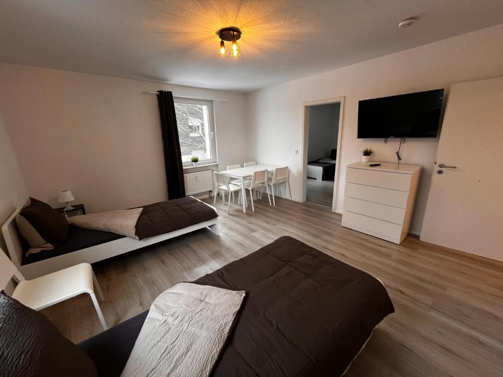 - un salon avec un lit, une télévision et une table dans l'établissement Tolle Monteursunterkunft für 6 Personen, à Ennepetal
