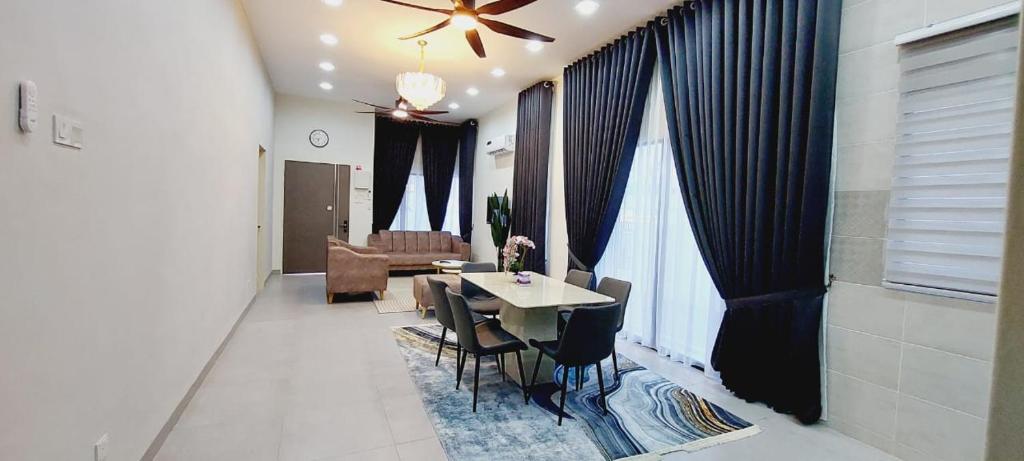 a dining room with a table and chairs and a living room at Family Homstay kulim Hitech in Kampong Sira