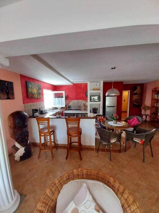 een keuken en een woonkamer met een tafel en stoelen bij Little Africa in Calodyne