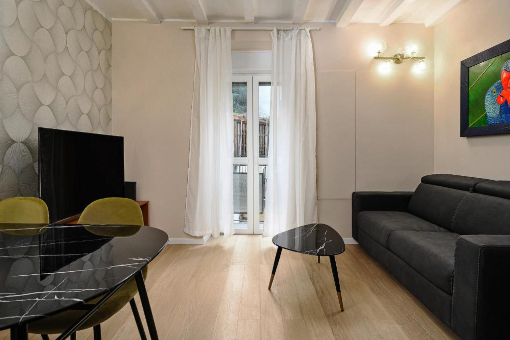 ein Wohnzimmer mit einem Sofa und einem Tisch in der Unterkunft Classbnb - Bilocale di design in zona Sempione in Mailand