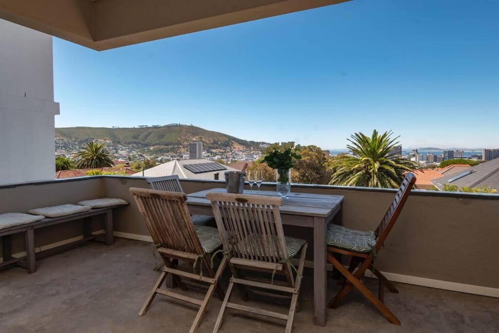 una mesa y sillas en un balcón con vistas en 2 Bedroom Apartment With Amazing City Views, en Ciudad del Cabo