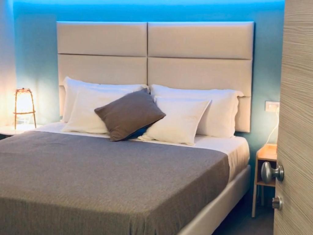 een slaapkamer met een groot bed met witte kussens bij ESMERALDA'S ROOMS in Porto San Paolo