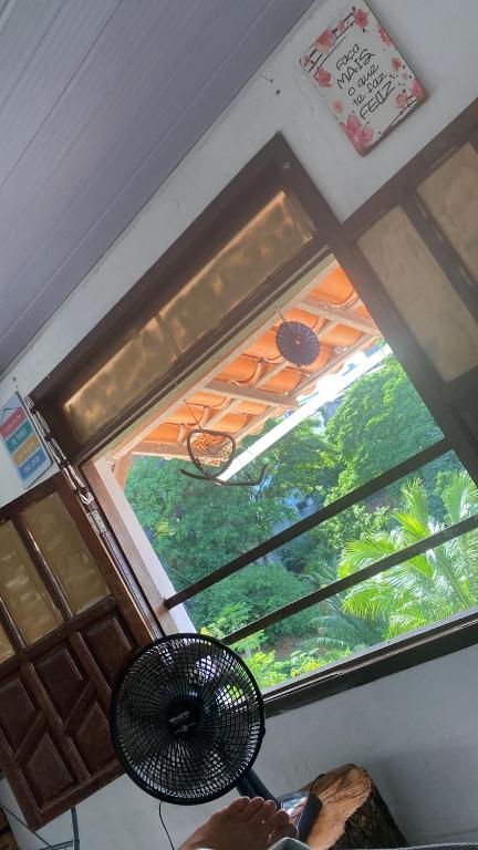 una ventana en una habitación con ventilador al lado en Apartamento temporada carnaval, en Salvador