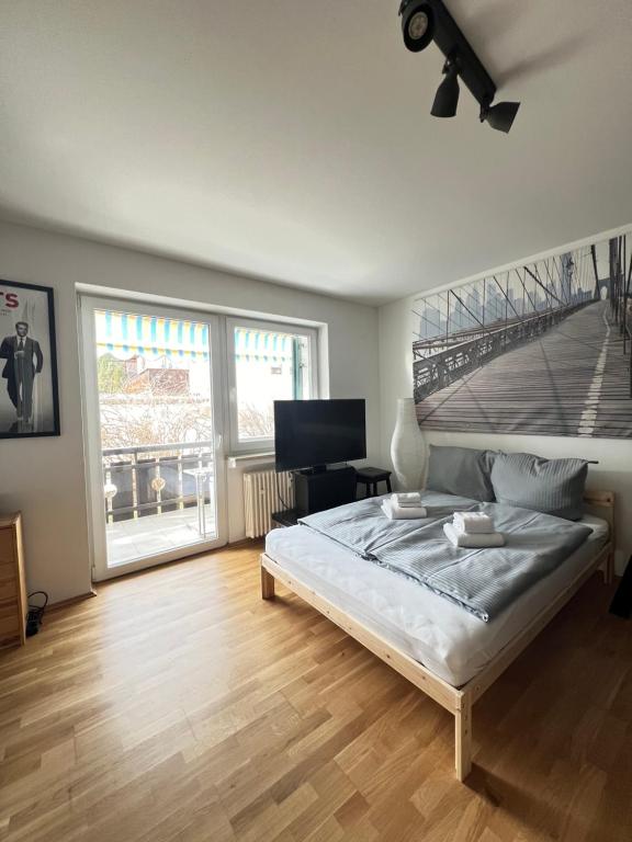 a bedroom with a bed and a large window at Mini Loft Apartment in Garmisch-Partenkirchen